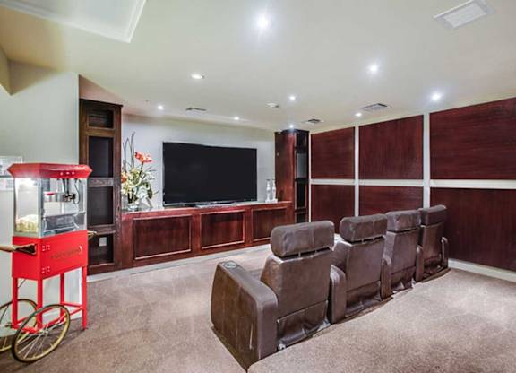 a living room with leather chairs and a television