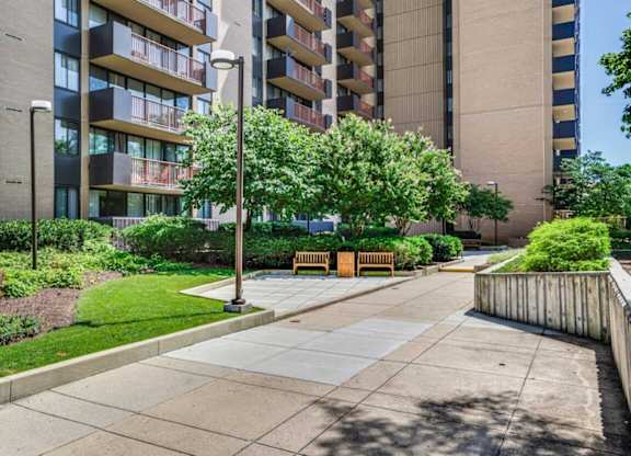 A modern apartment building with a well-maintained courtyard and landscaping.