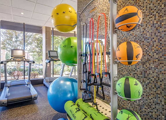 A gym with exercise balls and a treadmill.