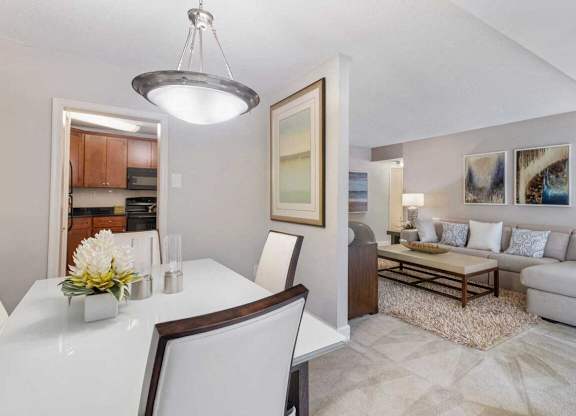 A modern dining room with a white table and chairs.