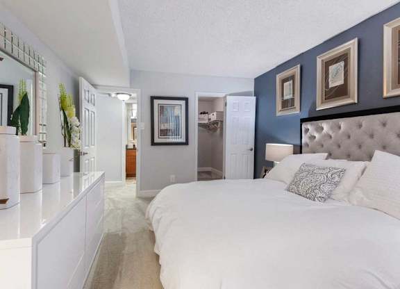 A bedroom with a large bed and a mirror on the wall.