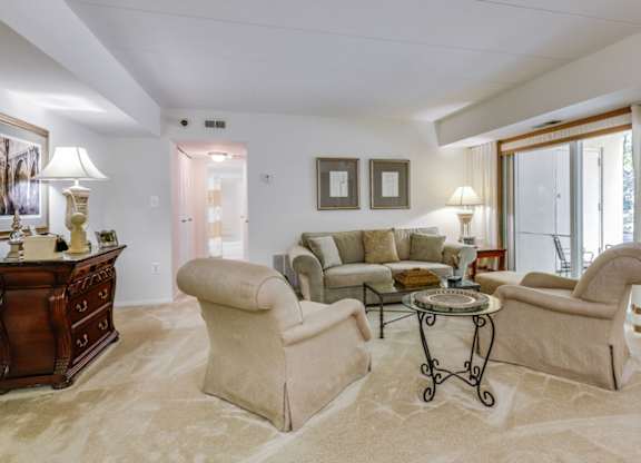 a living room with a couch and chairs and a table