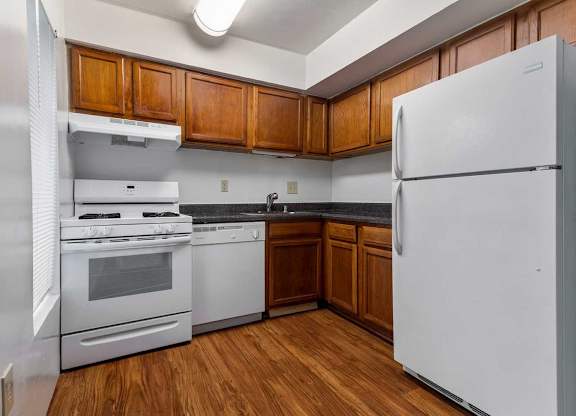 a kitchen with white appliances and wooden cabinets