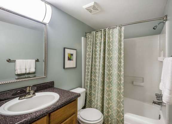 A bathroom with a toilet, sink, and shower.