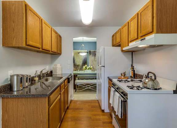 A kitchen with wooden cabinets and a white refrigerator.