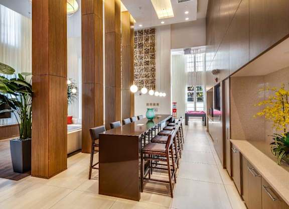 A long hallway with a brown reception desk and chairs.