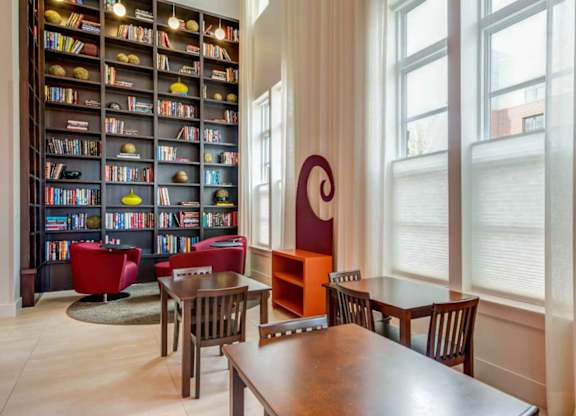 A children's room with a large bookshelf filled with books and a table with chairs.