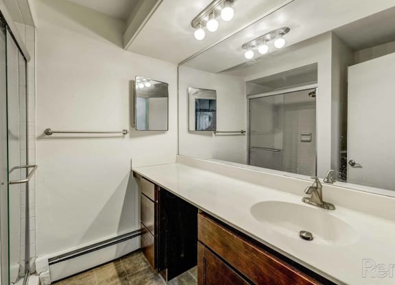 a bathroom with a sink and a mirror and a shower