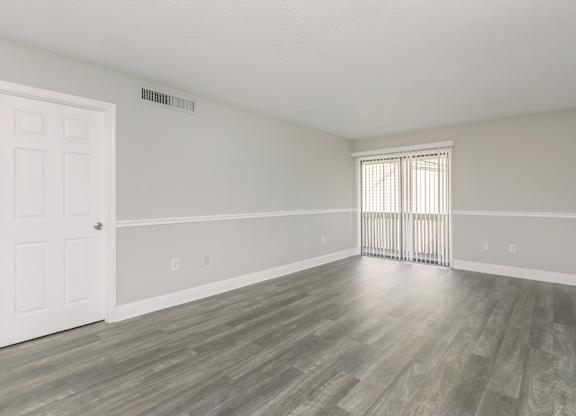 the living room and dining room of an apartment with wood flooring