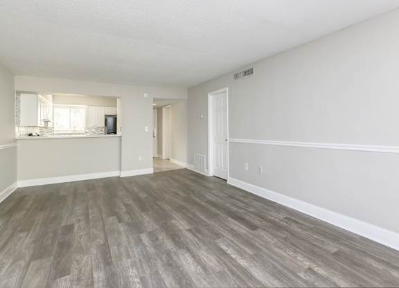 the spacious living room and kitchen of an apartment