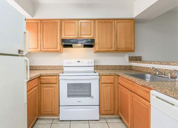 a kitchen with wooden cabinets and a stove and a sink