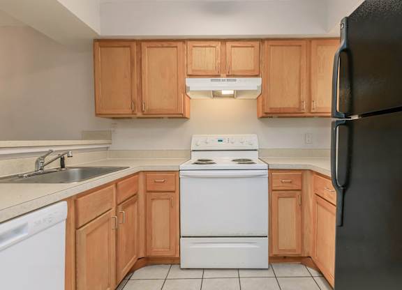 an empty kitchen with a stove refrigerator and sink