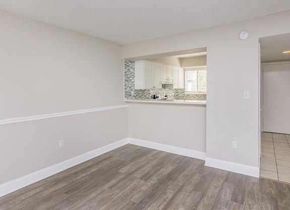 the living room and kitchen of an empty apartment