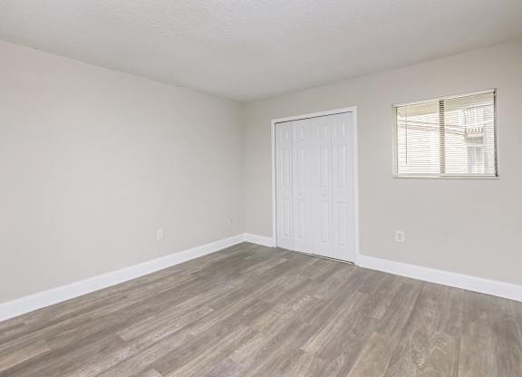 an empty living room with wood floors and a white door