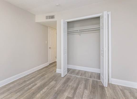 an empty bedroom with a closet with a sliding door