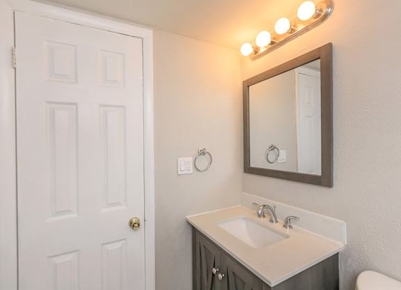 a white bathroom with two sinks and a mirror