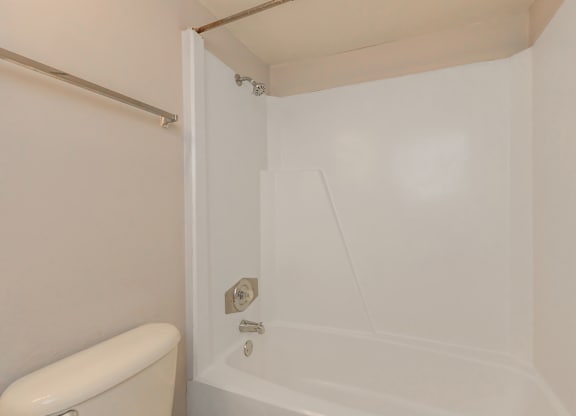 a white bathroom with a tub and a toilet