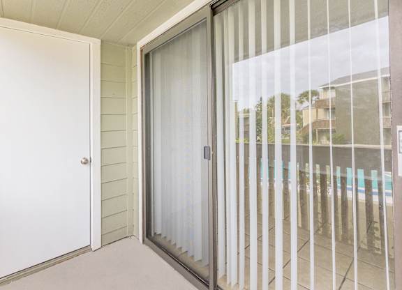 a sliding glass door leading to a balcony with a pool
