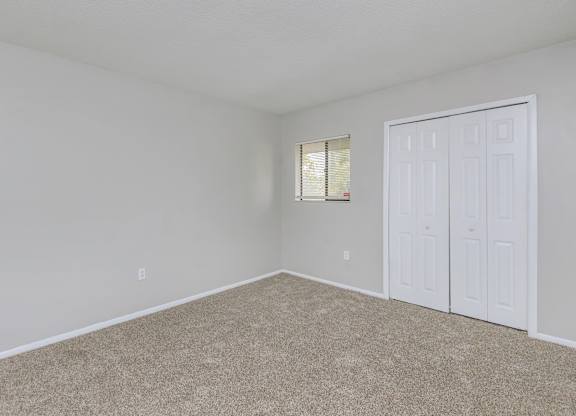 an empty bedroom with white walls and a white door