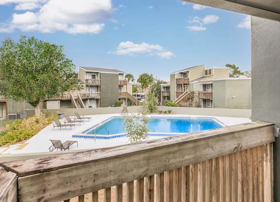 a view of the pool from the balcony of an apartment building