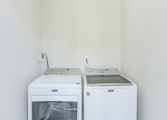 an empty kitchen with a stove and a washer and dryer
