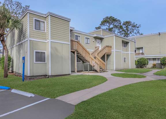 a row of homes with stairs in front of a sidewalk