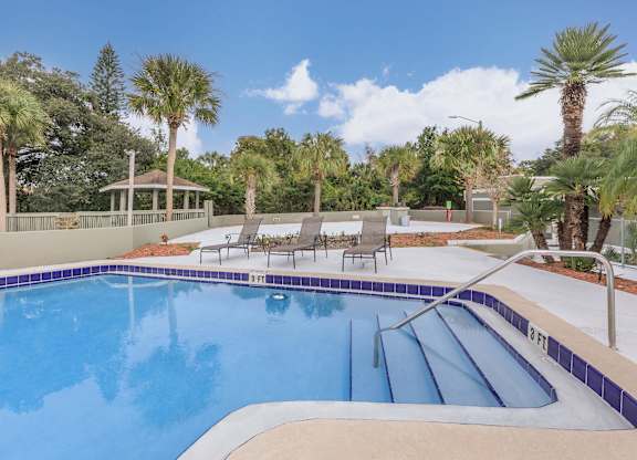 a swimming pool at a resort with palm trees