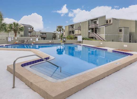 a large swimming pool in front of apartment buildings