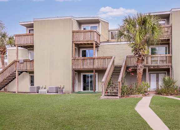 a building with stairs and a palm tree in front of it