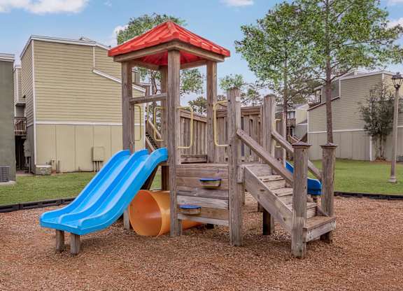 a playground with a blue slide and a wooden structure