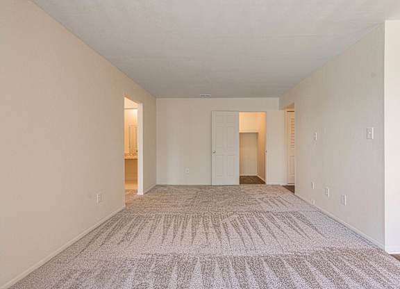 Open and airy carpeted living room at Knottingham Apartments in Clinton Township, MI