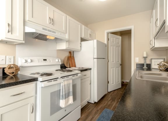 Kitchen with White Cabinets and Appliances at Three Oaks Apartments in Troy, MI