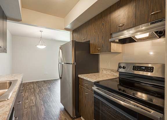 Modern kitchen with  stainless steel appliances and granite countertops at Knottingham Apartments in Clinton Township, MI