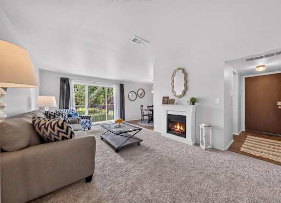 Elevated living room with a private balcony at Drawbridge Apartments in Harrison Township, MI.