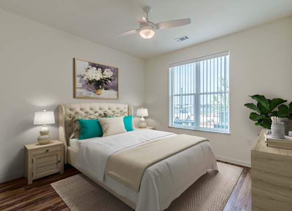 A bedroom with a large bed and a ceiling fan.