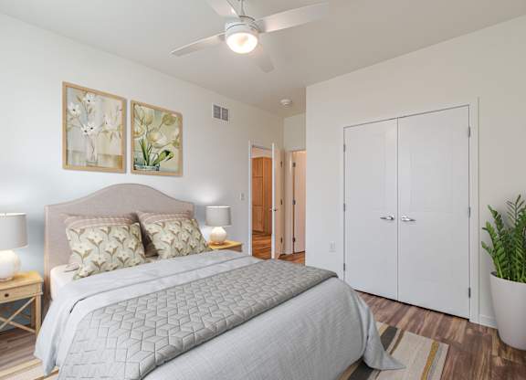 A bedroom with a large bed and a ceiling fan.