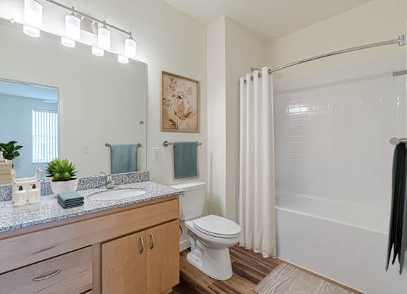 A bathroom with a toilet, sink, and shower.