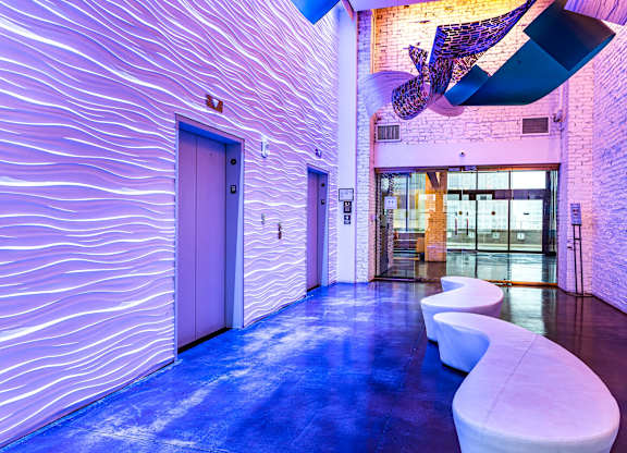 A hallway with a purple wall and a white door.