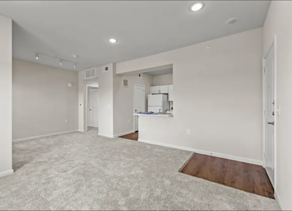 the living room and kitchen of a new home with white walls at Cypress Creek at River Oaks, Waxahachie