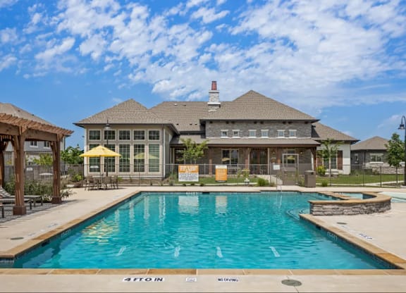 a large swimming pool in front of a house at Cypress Creek at River Oaks, Waxahachie, TX