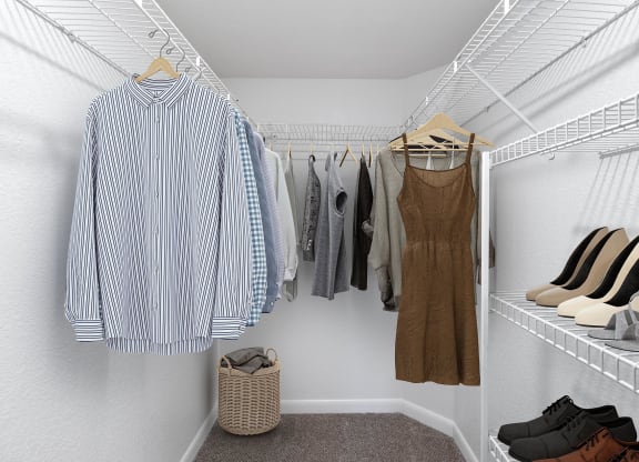 a walk in closet filled with clothes and shoes