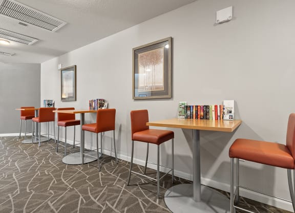 a community room with tables and chairs and a large window