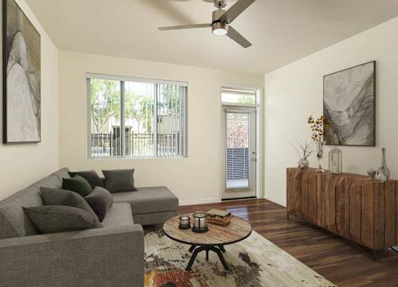 A living room with a grey couch, a wooden table, and a painting on the wall at Sandoval Flats Apartment , Rio Rancho, MN