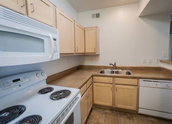 Kitchen with brown cabinets at Villa Springs, Houston, Texas