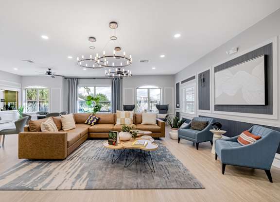 A modern living room with a large sectional sofa and a coffee table in the center.
