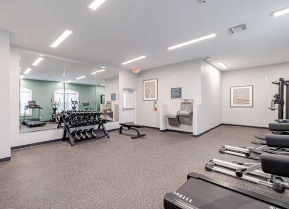 A gym with treadmills, weights, and exercise equipment.