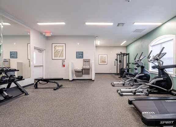 A gym with treadmills, elliptical machines, and other exercise equipment.