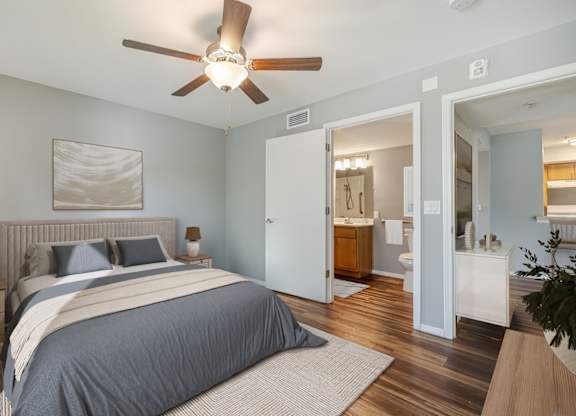 A bedroom with a large bed and a ceiling fan.