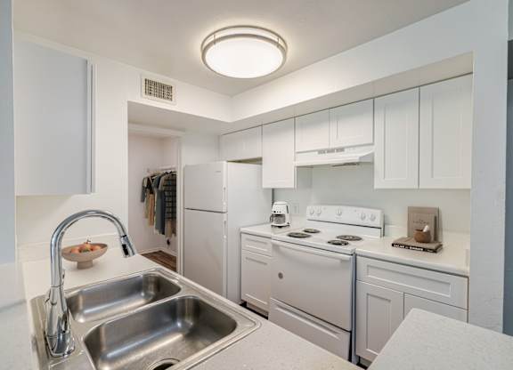 A kitchen with white appliances and cabinets.