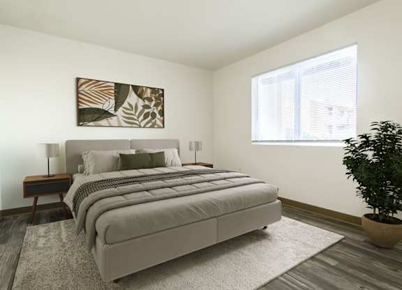 A bedroom with a large bed and a potted plant.